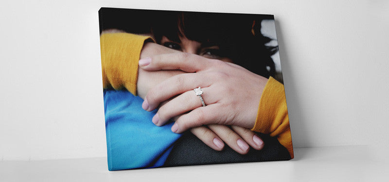 a canvas print leaning against a wall celebrating an engagement.  